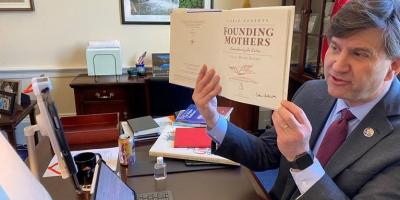 Congressman Schneider showing a book