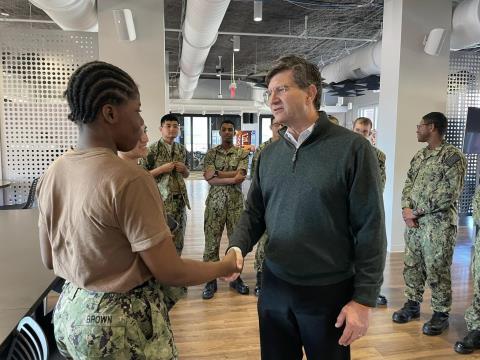 Brad shaking hands with servicemember. 